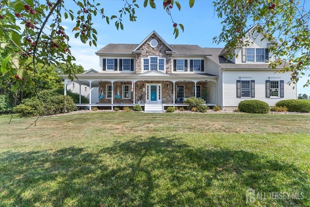 view of front facade featuring stone siding, a front lawn, and covered porch