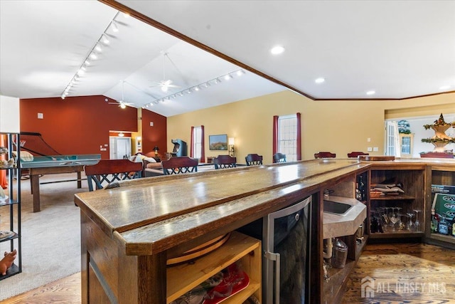 interior space with refrigerator, vaulted ceiling, carpet floors, track lighting, and recessed lighting