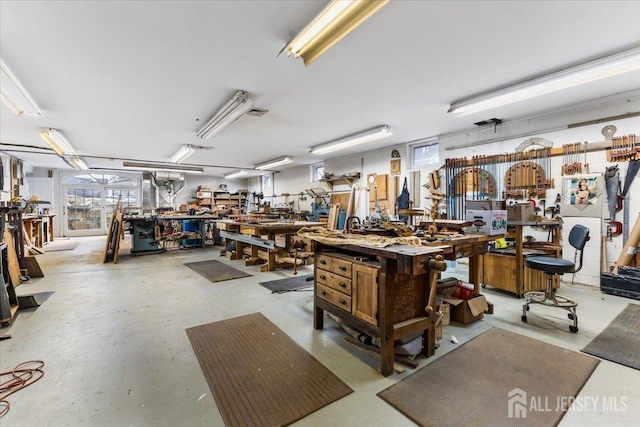 miscellaneous room with concrete flooring and a workshop area