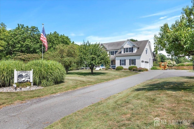 view of front of property featuring a garage, driveway, and a front lawn