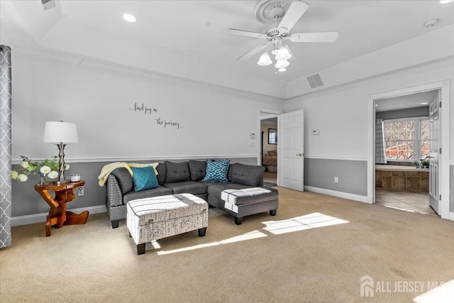 carpeted living room with crown molding, a ceiling fan, recessed lighting, a tray ceiling, and visible vents