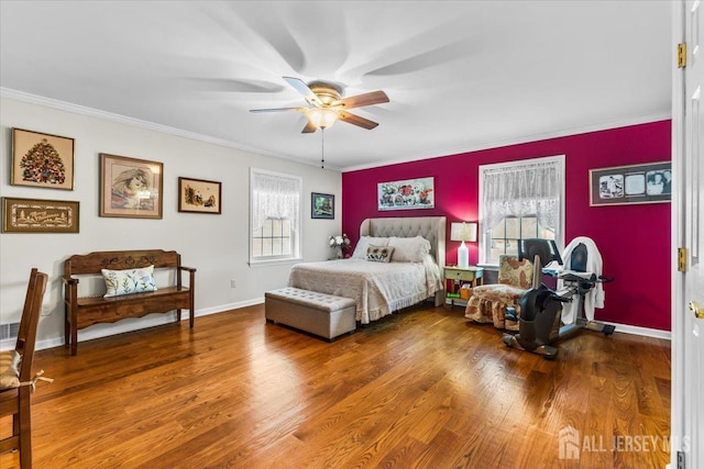 bedroom with crown molding, baseboards, ceiling fan, and wood finished floors