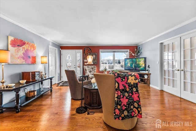living room featuring crown molding, baseboards, french doors, and wood finished floors