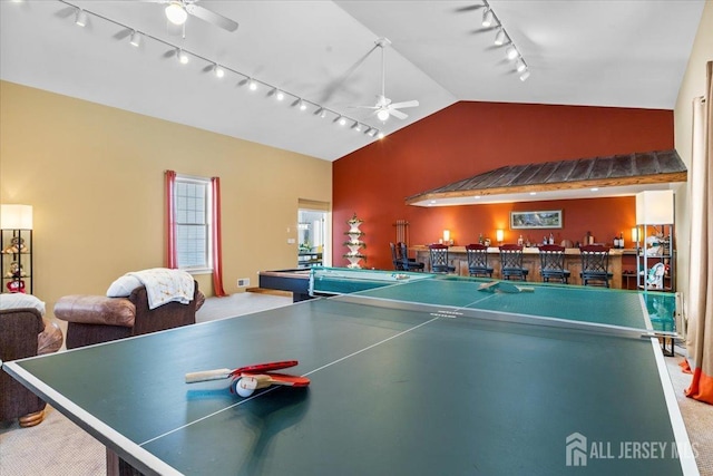 rec room with bar, a ceiling fan, rail lighting, carpet floors, and lofted ceiling