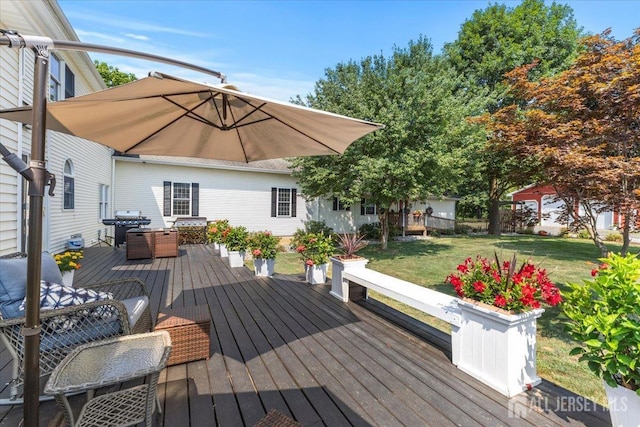 wooden deck with grilling area and a lawn