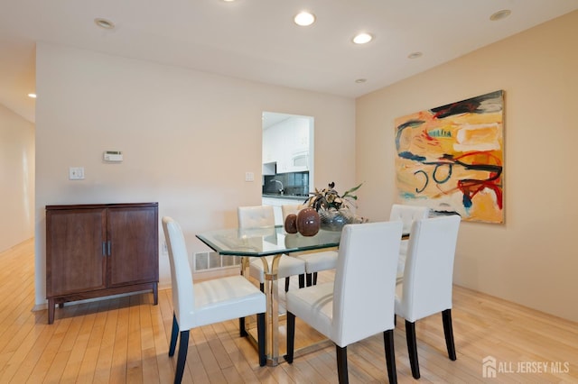 dining room with light wood-type flooring and recessed lighting