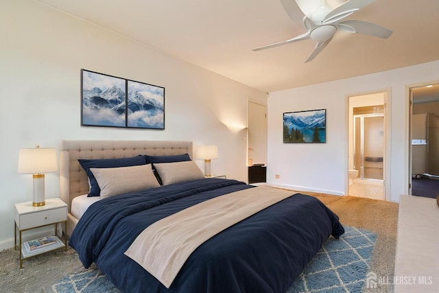 carpeted bedroom featuring ensuite bath, baseboards, and a ceiling fan