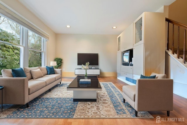 living room with recessed lighting, stairway, and wood finished floors