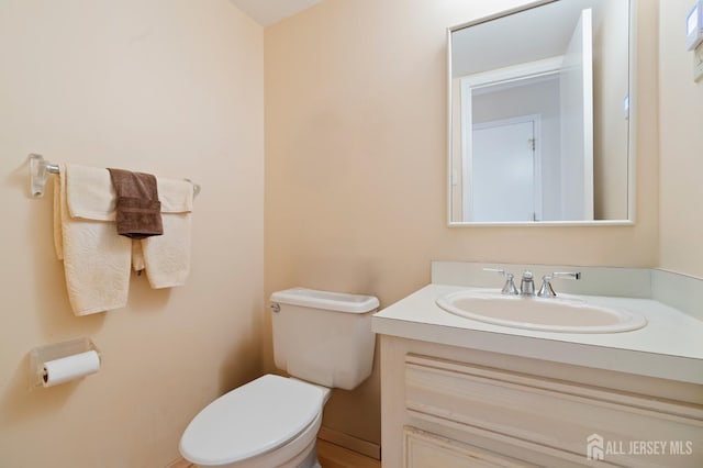 half bathroom with toilet and vanity