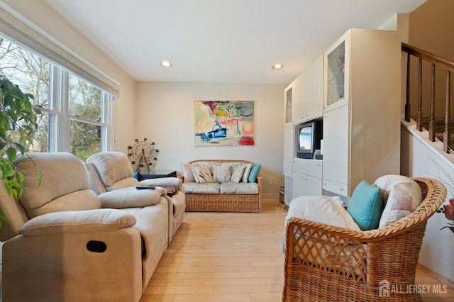 living area featuring light wood-style floors, recessed lighting, and stairs