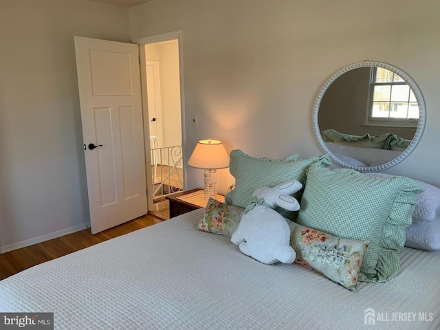 bedroom featuring wood finished floors and baseboards