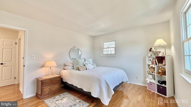 bedroom with light wood finished floors and baseboards