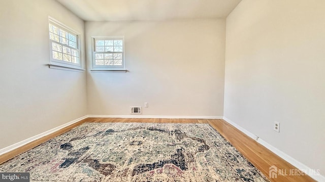 empty room featuring light wood-type flooring, baseboards, and visible vents