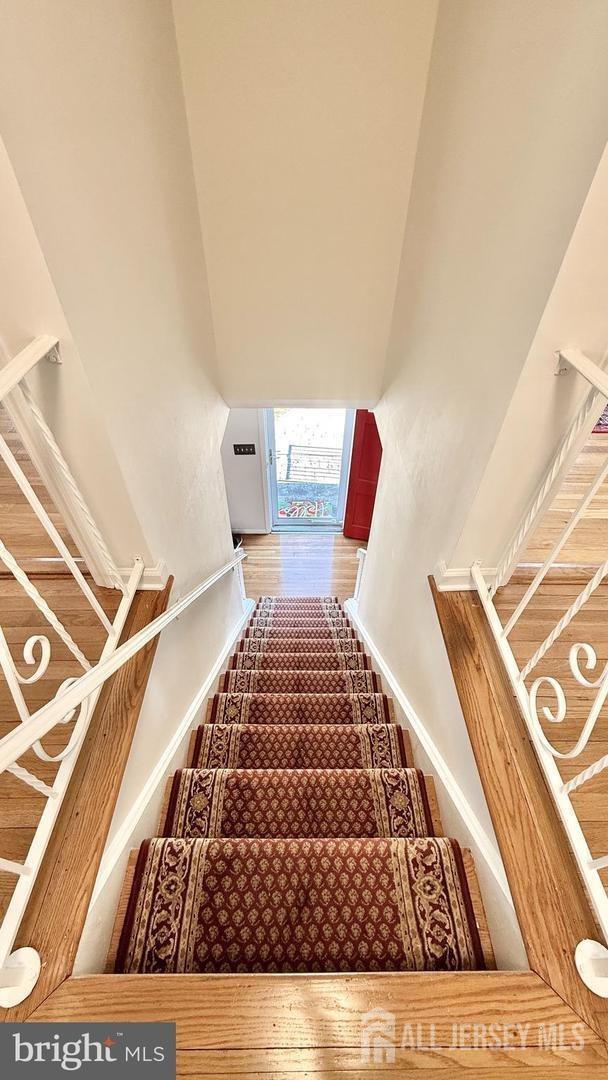 stairway with wood finished floors and baseboards