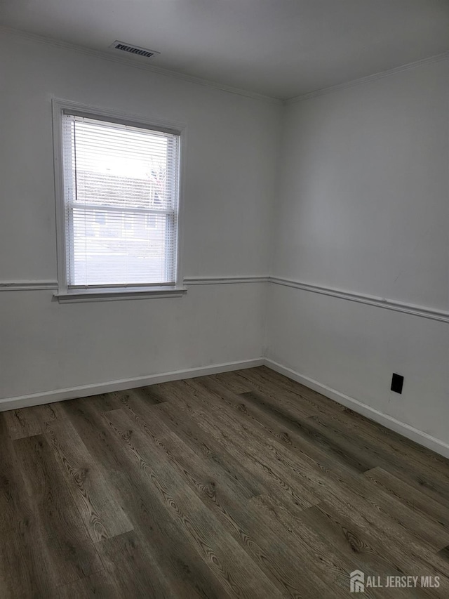 unfurnished room with visible vents, baseboards, and wood finished floors