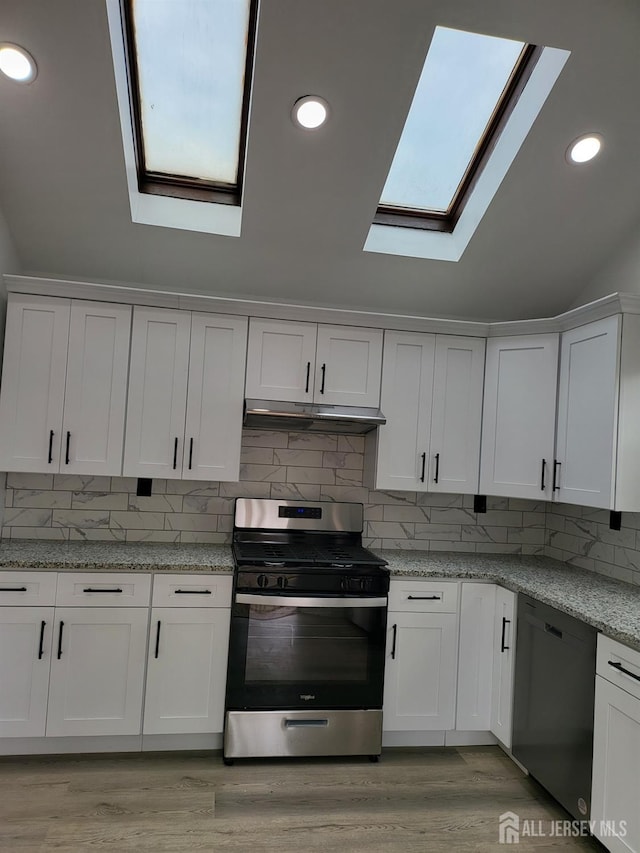 kitchen with under cabinet range hood, stainless steel gas stove, dishwasher, and white cabinetry