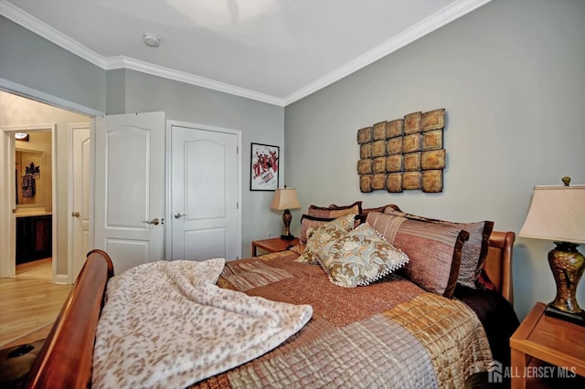 bedroom with wood finished floors and crown molding