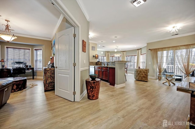 foyer entrance with visible vents, crown molding, light wood-style flooring, and baseboards