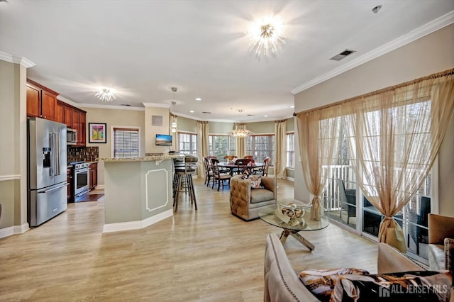 living area with an inviting chandelier, crown molding, visible vents, and light wood-style floors