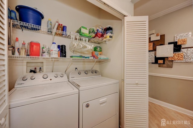 laundry area with laundry area, light wood finished floors, baseboards, independent washer and dryer, and crown molding