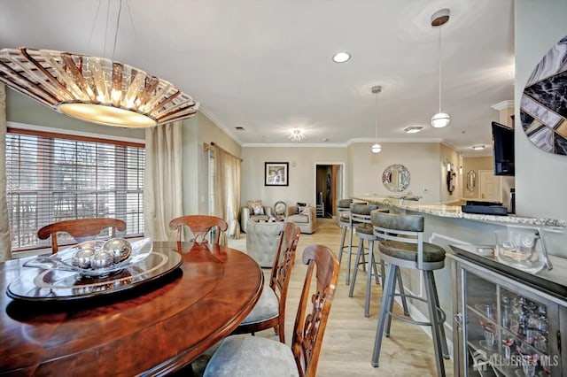 dining room featuring wine cooler, light wood-style flooring, and crown molding