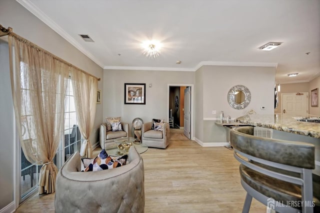 living room featuring baseboards, light wood finished floors, visible vents, and crown molding