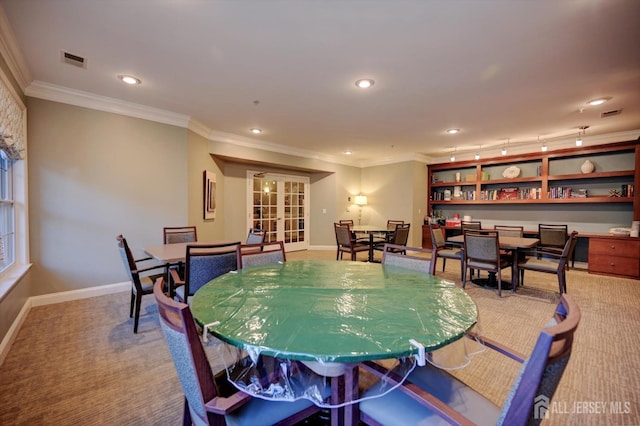 dining room featuring carpet floors, visible vents, crown molding, and baseboards