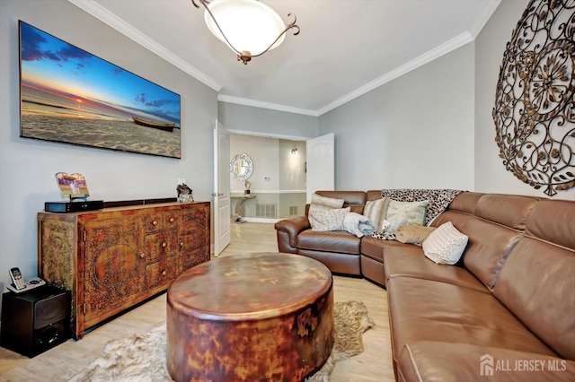 living area featuring ornamental molding, visible vents, and light wood finished floors