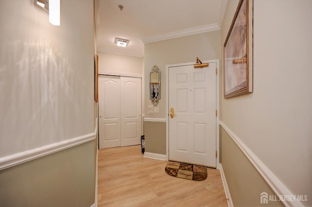 corridor with baseboards, light wood finished floors, and crown molding