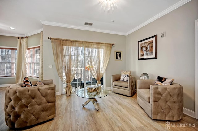 living room with visible vents, crown molding, light wood finished floors, and baseboards