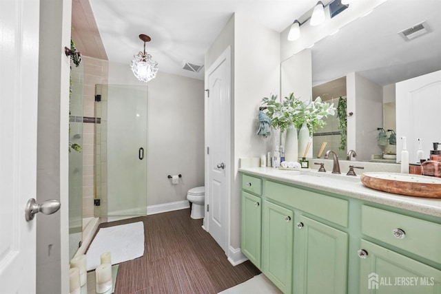 bathroom with vanity, toilet, and a shower with door