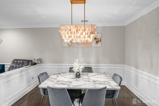 dining space featuring crown molding, dark hardwood / wood-style floors, and a notable chandelier