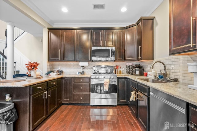 kitchen with sink, dark hardwood / wood-style flooring, ornamental molding, and stainless steel appliances