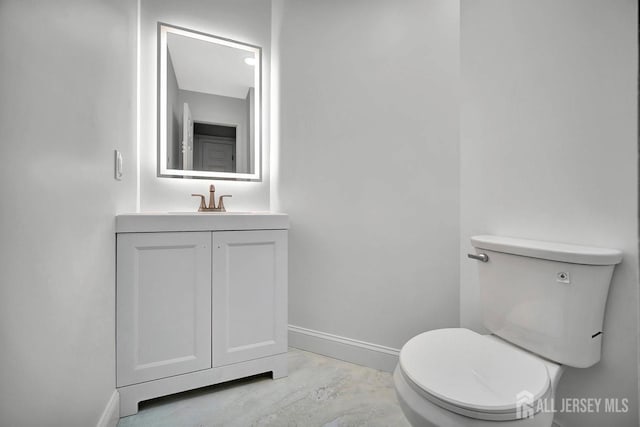 half bathroom with baseboards, concrete floors, toilet, and vanity