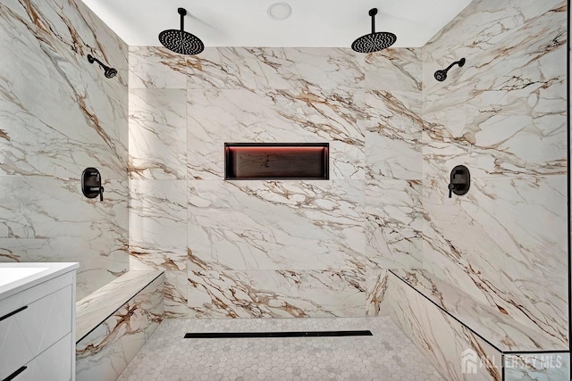 full bathroom with a marble finish shower, vanity, and tile walls