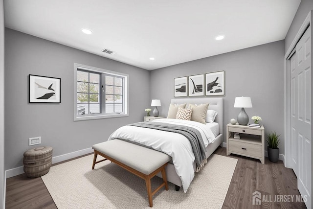 bedroom featuring a closet, dark wood-style flooring, baseboards, and recessed lighting
