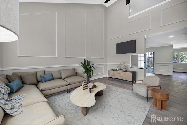 living area featuring a decorative wall, wood finished floors, and recessed lighting