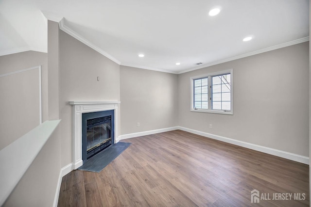 unfurnished living room with wood finished floors, a fireplace with flush hearth, baseboards, recessed lighting, and ornamental molding