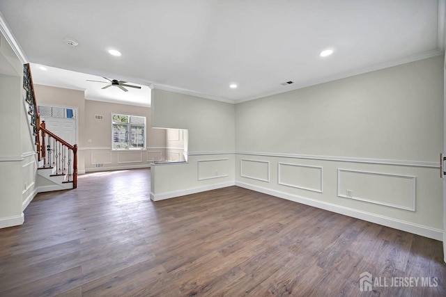 spare room with crown molding, a ceiling fan, stairs, recessed lighting, and a wainscoted wall