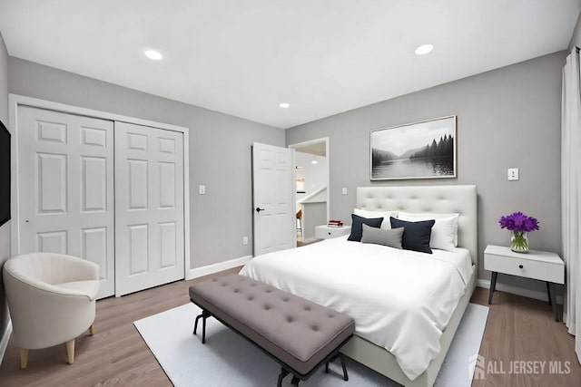 bedroom with light wood-style floors, a closet, baseboards, and recessed lighting