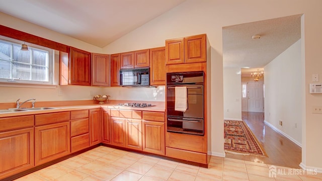 kitchen with black appliances, an inviting chandelier, sink, vaulted ceiling, and light tile patterned flooring