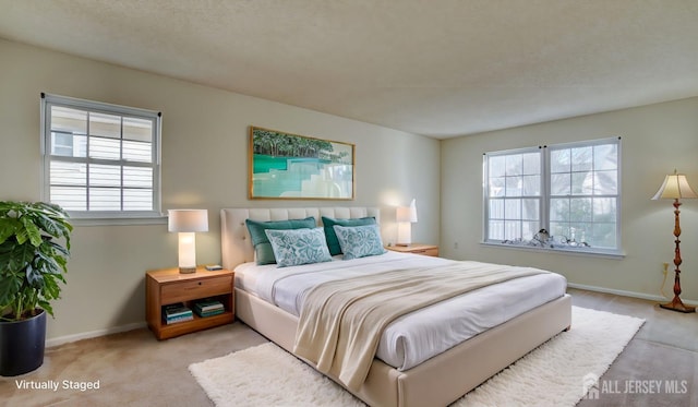 bedroom featuring a textured ceiling and light colored carpet