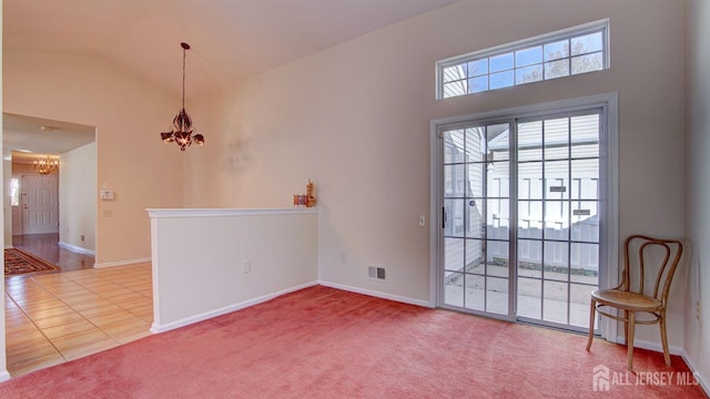 carpeted empty room with high vaulted ceiling and a notable chandelier