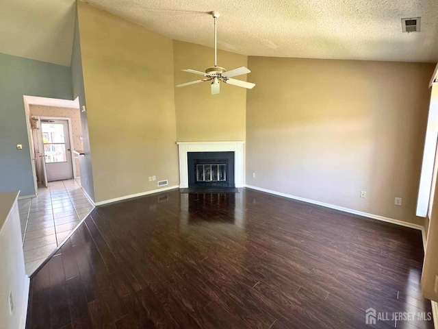 38 Rutland Ln Unit I, Monroe, NJ 08831 - unfurnished living room featuring wood finished floors, a ceiling fan, a fireplace with flush hearth, a textured ceiling, and high vaulted ceiling