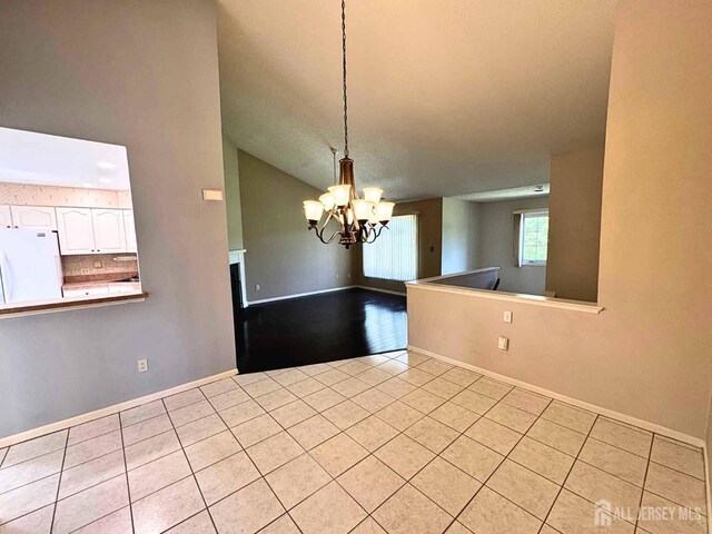 38 Rutland Ln Unit I, Monroe, NJ 08831 - unfurnished dining area featuring a chandelier, light tile patterned floors, baseboards, and high vaulted ceiling