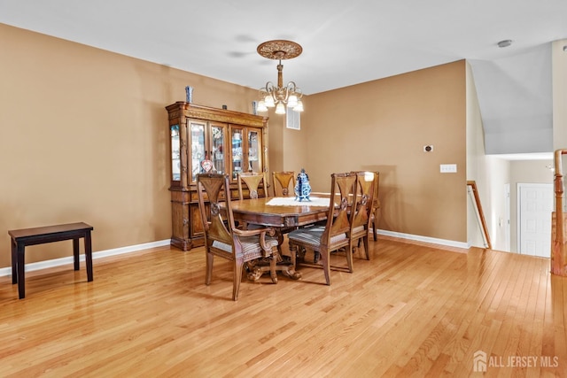 dining space featuring light hardwood / wood-style floors and a chandelier