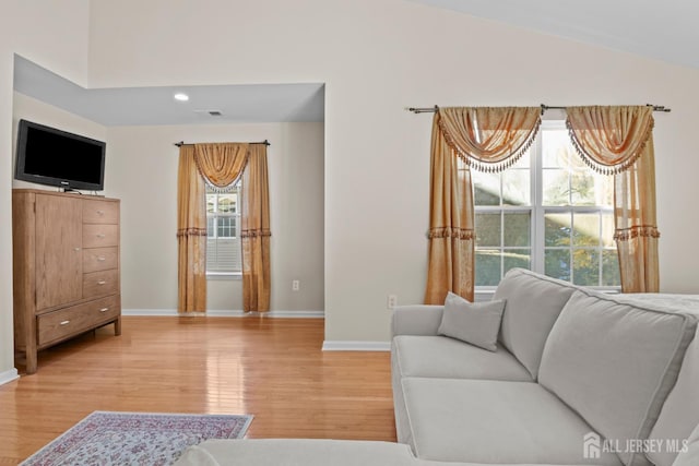 living room with lofted ceiling and light hardwood / wood-style flooring