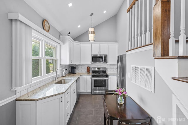 59 Mckinley Ave, Colonia, NJ 07067 - kitchen with stainless steel appliances, a sink, backsplash, white cabinetry, and vaulted ceiling