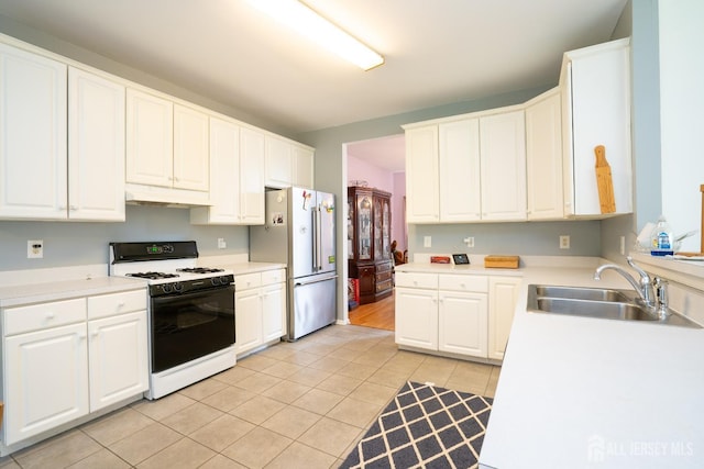 7 Sequoia Dr, South Brunswick, NJ 08810 - kitchen with range with gas stovetop, a sink, freestanding refrigerator, light tile patterned floors, and white cabinetry