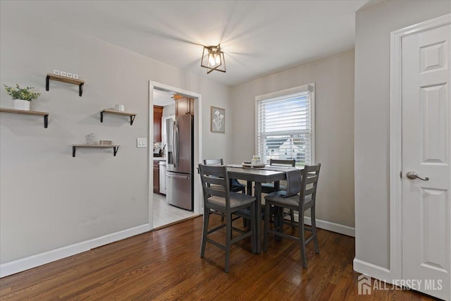 dining area with baseboards and wood finished floors